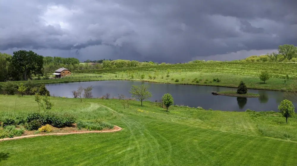 Storm clouds over the pond and lawn